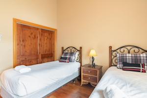 - une chambre avec 2 lits et une porte en bois dans l'établissement Cimarron Lodge 35 by AvantStay Ski-InSki-Out Property in Complex w Two Hot Tubs, à Telluride