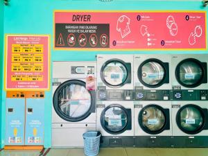 um grupo de quatro máquinas de lavar roupa numa lavandaria em Cozy Scandi home @ Balok! em Kampung Saberang Balok