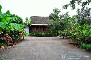 a house with a dirt road in front of it at บ้านสวนอุดมสวัสดิ์ อัมพวา in Amphawa