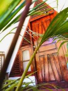 ein Haus mit einer Holztür hinter einer Palme in der Unterkunft Singh Brothers in Nallathanniya