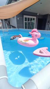 una piscina con un giocattolo rosa per maiali di Melaka Homestay with pool 4BR Semi-D,BBQ,KTV,Billiard 15pax DeStarryVilla a Malacca