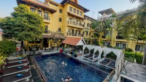 un hotel con piscina frente a un edificio en Villa Indochine d'Angkor, en Siem Reap