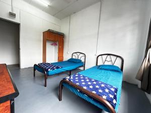 een kamer met 2 bedden in een kamer bij Jiaxin Dormitory - Puteri Wangsa 家馨旅舍 in Ulu Tiram