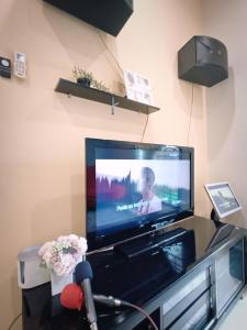 a flat screen tv sitting on top of a entertainment center at Melaka Homestay with pool 4BR Semi-D,BBQ,KTV,Billiard 15pax DeStarryVilla in Melaka