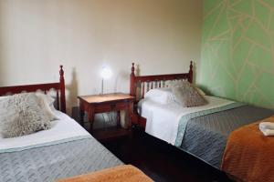 ein Schlafzimmer mit 2 Betten und einem Tisch mit einer Lampe in der Unterkunft "Tu refugio espacioso en el corazón de MENDOZA y el PARQUE" in Mendoza