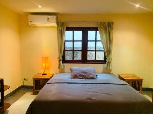 sypialnia z dużym łóżkiem i oknem w obiekcie Scan House Apartment w mieście Karon Beach