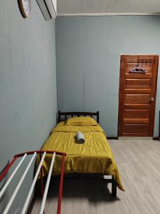 1 dormitorio con 1 cama con manta amarilla en ROO STAy TOK WAN 1, en Kampong Nail