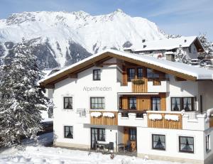 un hotel con montañas cubiertas de nieve en el fondo en Mutzkopf en Nauders