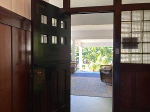 an open door to a room with a view of a house at Hilo Bay Oceanfront Bed and Breakfast in Hilo