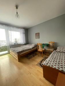 a bedroom with two beds and a table and chairs at agroturystyka Pensjonat PAULA in Muszyna