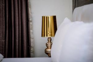 a lamp sitting on a table next to a bed at Mohouse Hotels and Apartments Mabushi in Abuja