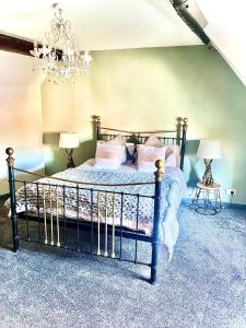 a bedroom with a bed with a chandelier at Little Libertys in Shrewsbury