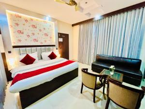 a bedroom with a large bed and a desk and a bed sidx sidx sidx at The Ramawati - A Four Star Luxury Hotel Near Ganga Ghat in Haridwār