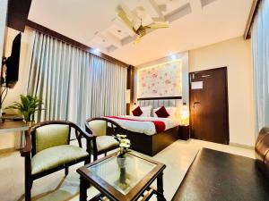 ein Hotelzimmer mit einem Bett, einem Tisch und Stühlen in der Unterkunft The Ramawati - A Four Star Luxury Hotel Near Ganga Ghat in Haridwar