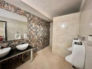 a bathroom with two sinks and a mirror at The Ramawati - A Four Star Luxury Hotel Near Ganga Ghat in Haridwār