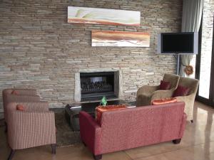 a living room with two chairs and a fireplace at Maropeng Boutique Hotel in Magaliesburg