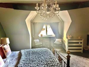 a bedroom with a chandelier and a bed with two chairs at Little Libertys in Shrewsbury