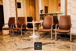a group of chairs and a table in a room at Mohouse Hotels and Apartments Mabushi in Abuja