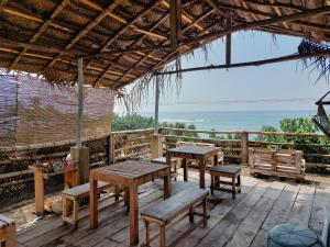 阿漢伽馬的住宿－Gaia Ocean Surf Yoga，一个带桌子和长椅的海景庭院