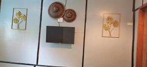 uma parede com uma televisão e algumas imagens sobre ela em Ecostay Panglao Resort Hotel em Panglao