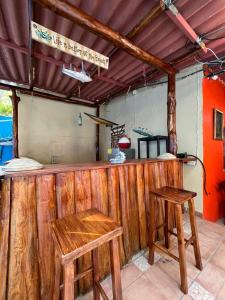 a bar with two wooden stools and a bench at Rancho de monica in El Majahual