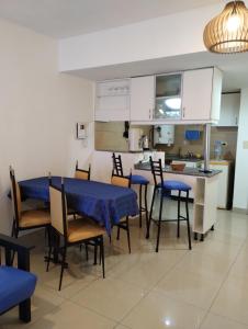 Monoambiente Tres Barrios في بوينس آيرس: مطبخ وغرفة طعام مع طاولات وكراسي زرقاء