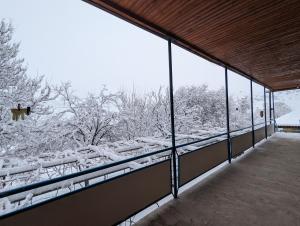 a snow covered balcony with a view of trees at Sofia in Vardzia