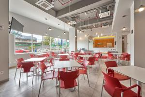 a dining room with tables and red chairs at City Express Junior by Marriott Ciudad del Carmen Aeropuerto in Ciudad del Carmen