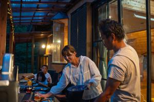 Eine Frau und ein Mann bereiten Essen in einem Restaurant vor. in der Unterkunft Ryojukukan Villa Nasukogen in Nasu