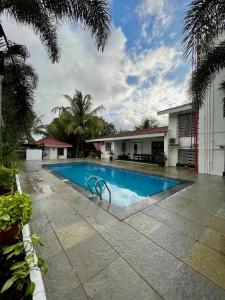 a swimming pool in front of a building at The Green Estate Resort in Nashik