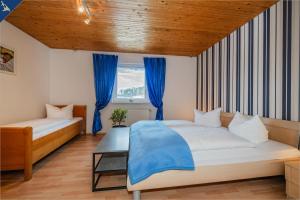 1 dormitorio con 1 cama y una ventana con cortinas azules en Ferienhaus Olé FH Olé Wiesenblick Appartement, en Heringsdorf