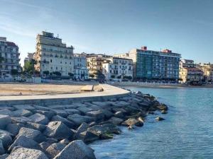 a group of rocks in the water next to buildings at LA CASA CHE VORREI in Crotone