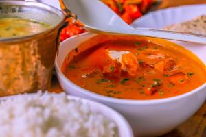 a bowl of soup on a table with some rice at GeoLux - Luxurious Geodesic Dome in Chikmagalur