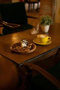 - une table avec une assiette de nourriture et une tasse de café dans l'établissement De Karanganjar Inn, à Berni