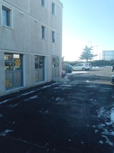 un aparcamiento vacío frente a un edificio en Premiere Classe Saint Brice Sous Foret, en Saint-Brice-sous-Forêt