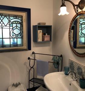 een badkamer met een wastafel en een spiegel bij Aprisa apartment in Piedimonte Etneo