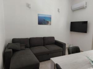 ein Wohnzimmer mit einem Sofa und einem Flachbild-TV in der Unterkunft Levante in Terrasini