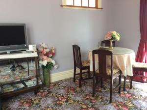 a dining room with a table and a television at Catlins Retreat B & B in Owaka