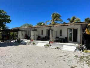 a white building with palm trees in the background at Fare Mahai in Avatoru