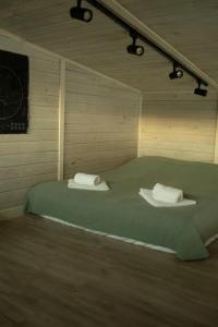a room with a bed with two towels on it at Country House in Almaty
