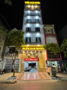 um edifício branco alto com um cartaz em Tuan Nam Hotel em Haiphong