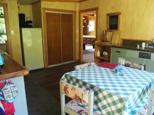 a kitchen with a table with a checkered table cloth at Woodland eco retreat in Parapara 