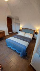 een slaapkamer met een groot bed in een kamer bij Appartement médiéval au cœur du village de Lama in Lama