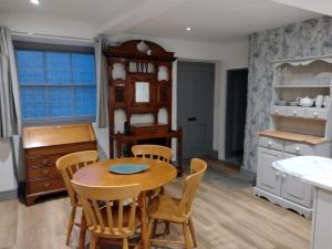 cocina con mesa de madera y sillas en Lavender Cottage, Masham, Historic Listed, 2 bedrooms en Masham