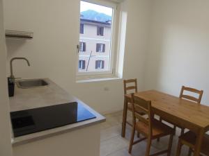 uma cozinha com uma mesa de madeira e uma janela em Apartaments Claudia Augusta em Bolzano