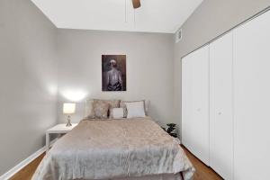 a white bedroom with a bed and a lamp at Prime Area In Philly - Large Lovely Apartment in Philadelphia