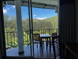 einen Balkon mit einem Tisch und Stühlen sowie Aussicht in der Unterkunft Ella Silloam in Ella