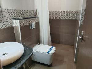 a bathroom with a white toilet and a sink at SMA Grand inn, Triplicane in Chennai