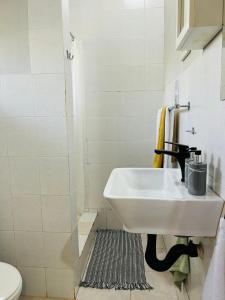 a white bathroom with a sink and a shower at Sabie Stay in Sabie