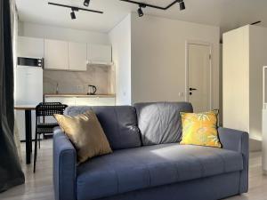 un sofá azul en una sala de estar con cocina en Seven City 24, en Semey